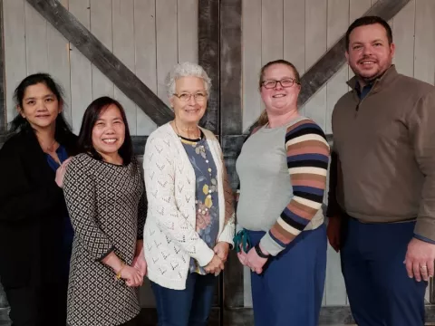 A group of co-workers standing next to each other.