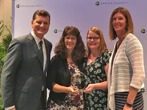 A group of co-workers standing next to each other.