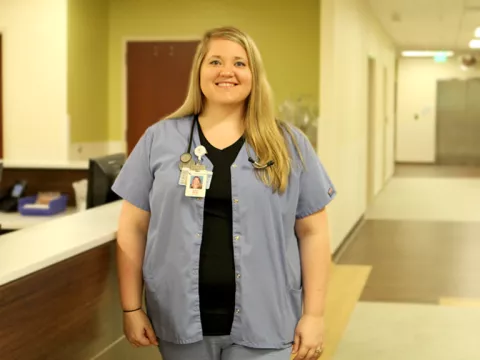 A white woman standing in a hall at the hospital 