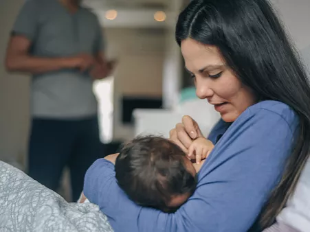 A mother breastfeeds her newborn baby.