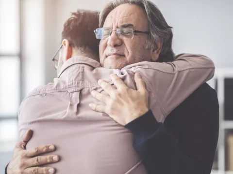 Two men are hugging comfort each other in their time of need.