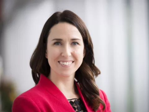 Gina Creek, woman with brown hair and blue eyes, smiles at the camera