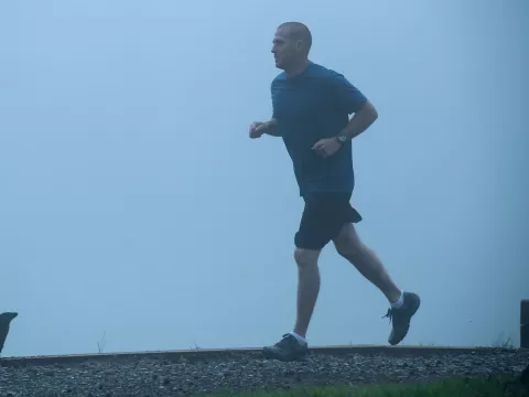 Man out for a jog in the fog.