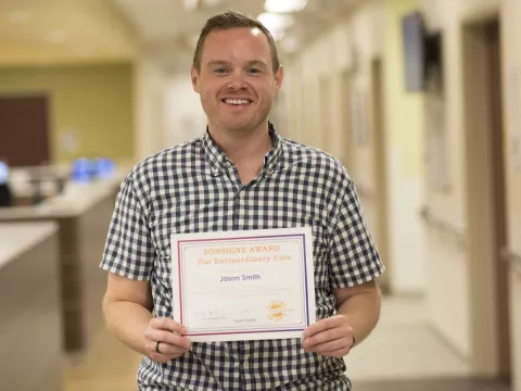 Jason Smith holding an award. 