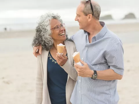 A couple enjoys a walk on the beach together.