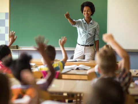 A healthy teacher calls on a student in class.