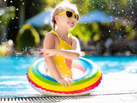 A little girl enjoys a refreshing dip in the pool.