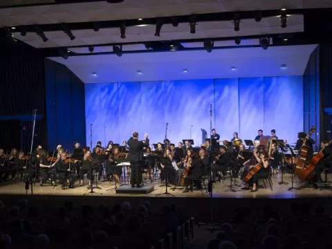 AdventHealth Orchestra performing on an indoor stage.