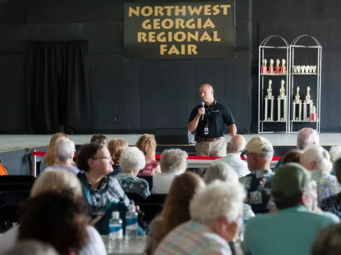 Doctor Land speaking in front of seniors at a public event