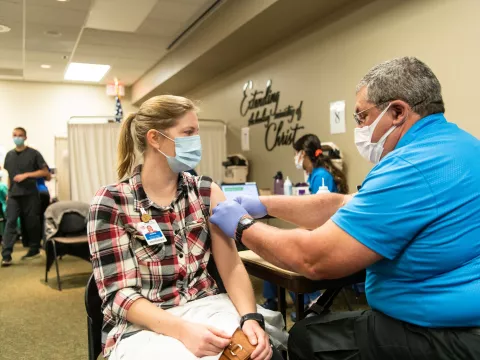 Female AdventHealth employee receives Moderna vaccine from male employee