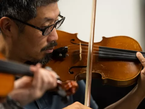Dr. Vincent Hsu practices with the AdventHealth employee orchestra.
