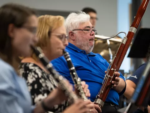 Ian Barnett, right, practices with the AdventHealth employee orchestra.