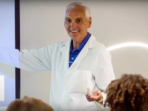 Older male Adventist professor teaching a class.