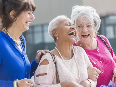 Three women laughing and shopping.