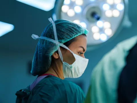 A surgeon wearing a mask performing surgery
