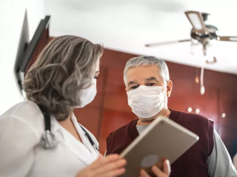 Mature female doctor talking to a male patient