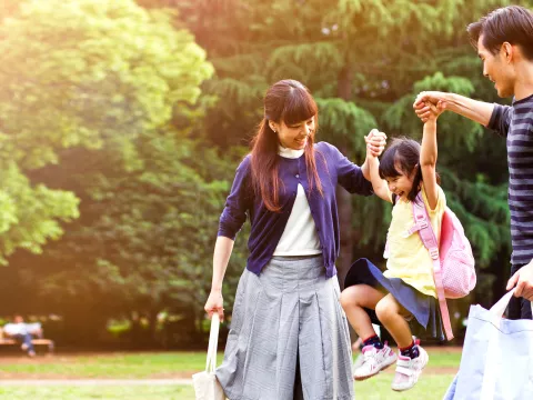 A family of three, ouside, the father and mother.