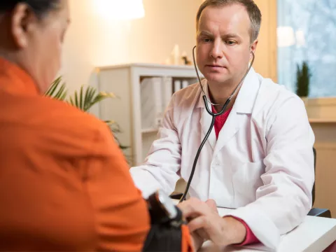 Doctor checking a patient's blood pressure.
