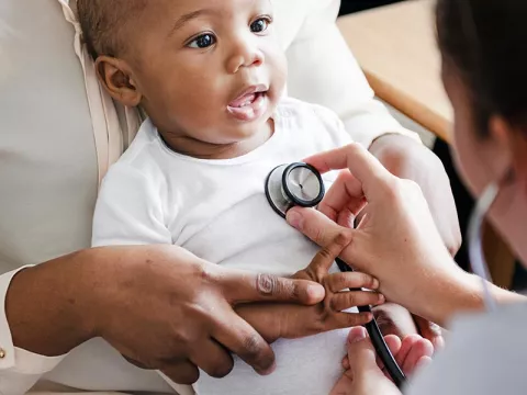 Doctor listening to baby's heartbeat with stethoscope