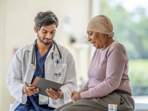 Doctor explaining to an older woman cancer patient her test results.