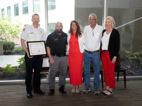 Group photo with man holding certificate
