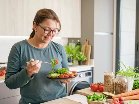 A woman eating a health plant-based meal.