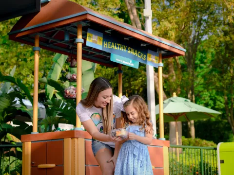 A Mother and Daughter Stop for a Healthy Snack at the EPCOT Flower and Garden Festival Butterfly Landing
