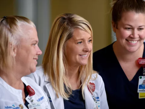Three Health Care Providers Smile as They Interact on the Job