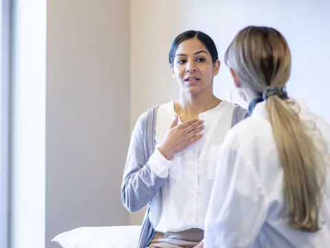 A young woman speaks to her female doctor.