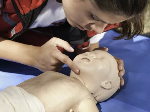 Person preparing to practice cpr on a mannequin