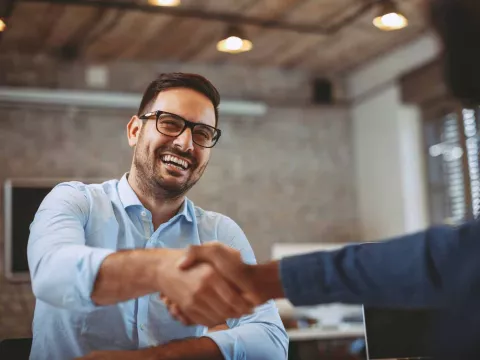 A man gives a handshake to the interviewer at a job interview