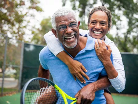 woman hugging man with tennis racket