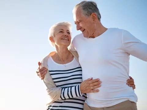 A couple walks on the beach after a successful hernia surgery.
