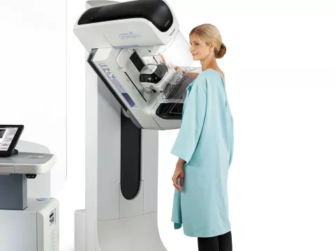 A woman getting a mammogram done with a 3D mammography machine