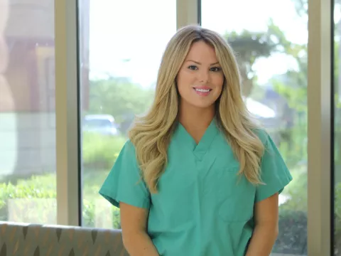 A white nurse posing for a photo.
