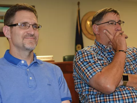 Two men have their attention on something in a government room