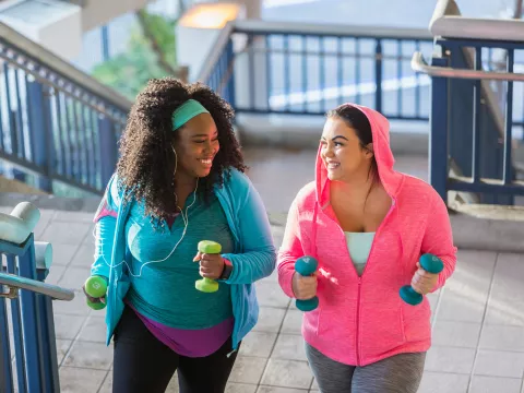 Two women exercising by running up some stairs
