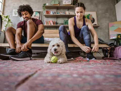 A couple lacing up their shoes for a workout together. 