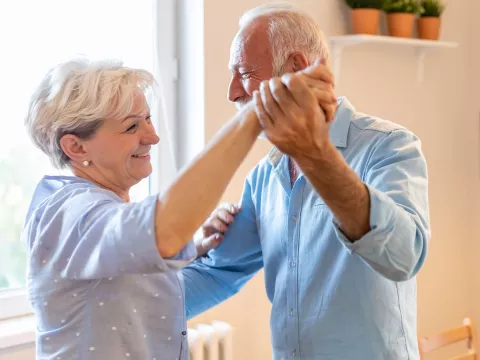 A couple dancing in the kitchen.
