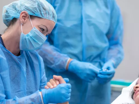A doctor holding a patient's hand in the emergency room. 