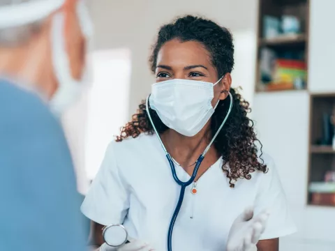 Doctors talking with each other while wearing masks.