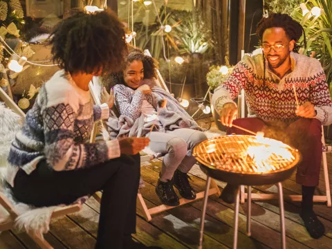 A family roasting marshmallows outside.