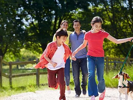 Family walking their dog along a dirt road