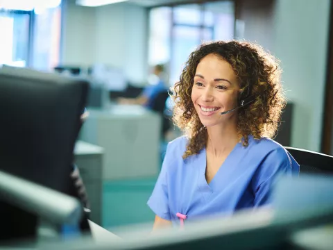 Woman in scrubs on phone headset