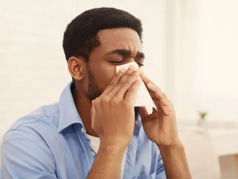 A man blowing his nose. 