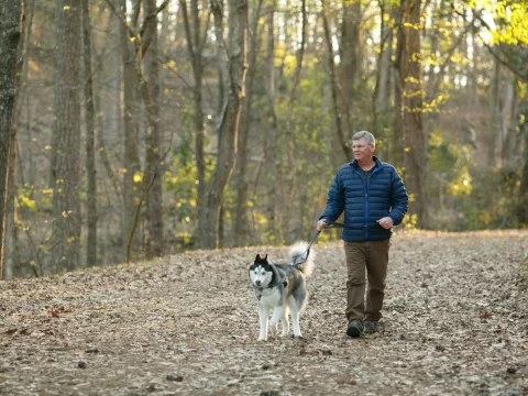 Mark and his dog walking in the woods