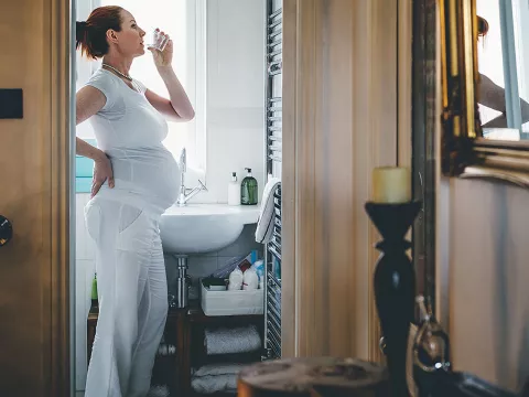 A pregnant woman drinking water.