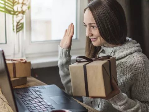 A woman doing a gift exchange on a video call.