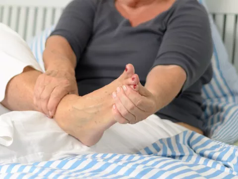 A senior woman massages her foot
