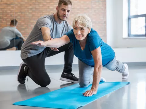 A woman does strengthening exercises with her physical therapist.